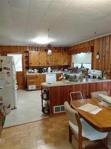 a dining room with a table chairs and a kitchen view
