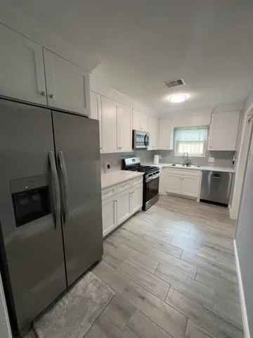 a kitchen with stainless steel appliances granite countertop a refrigerator sink and stove