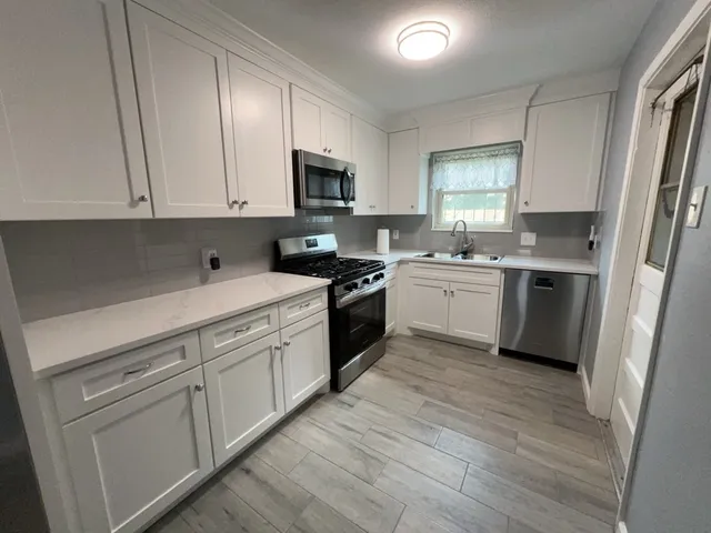 a kitchen with white cabinets and white appliances