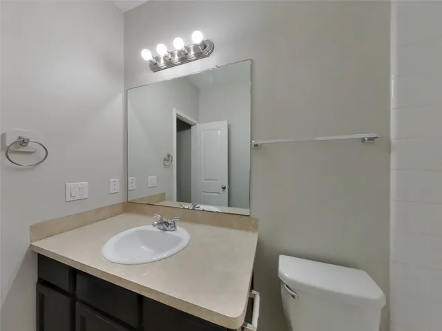 a bathroom with a sink toilet and mirror