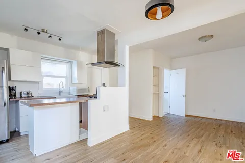 a kitchen with sink cabinets and wooden floor