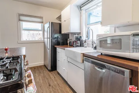 a view of a kitchen with refrigerator and wooden floor