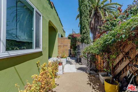 a view of a backyard with table and chairs potted plants