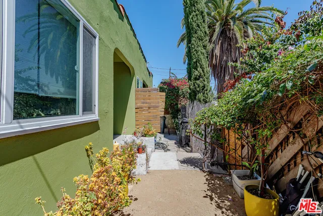 a view of a backyard with table and chairs potted plants