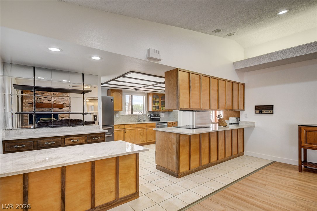 1401 Sharon Road Las Vegas, NV 89106 - Photo 35 of 73 Rich wood cabinetry paired with light stone countertops defines this open culinary space.