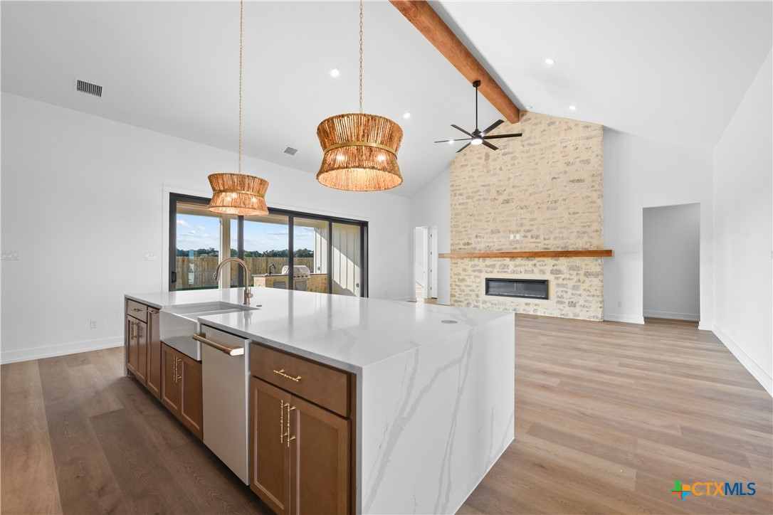 6807 Lacey Oak Road Salado, TX 76571 - Photo 12 of 41 a kitchen with stainless steel appliances granite countertop a stove and a wooden floor