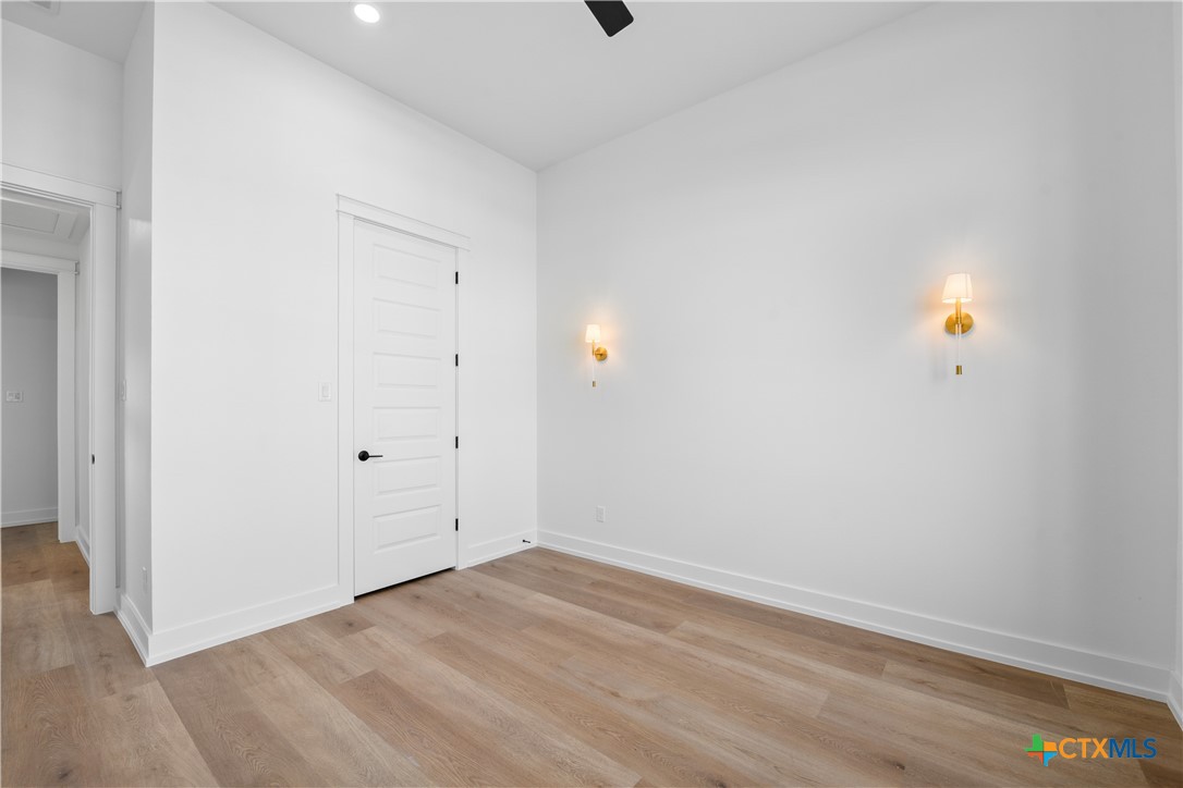 6807 Lacey Oak Road Salado, TX 76571 - Photo 18 of 41 a view of an empty room with wooden floor and windows