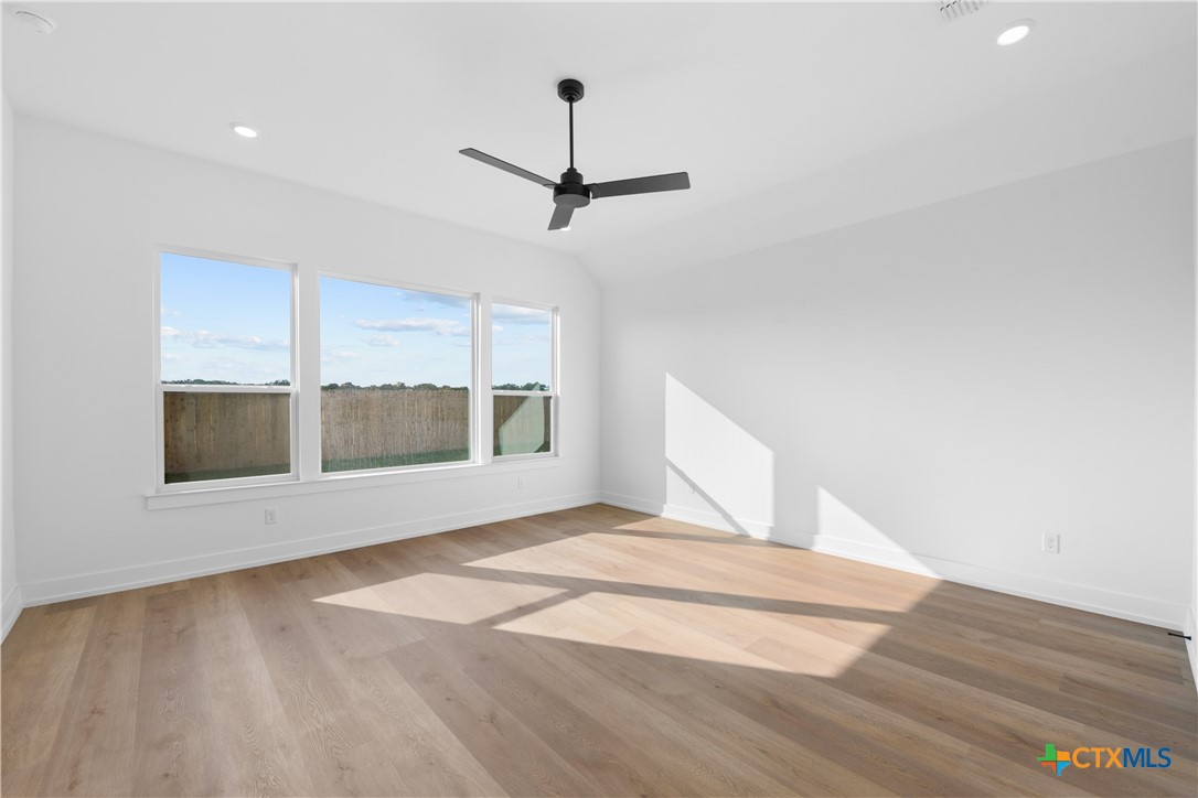 6807 Lacey Oak Road Salado, TX 76571 - Photo 21 of 41 a view of an empty room with a window and wooden floor