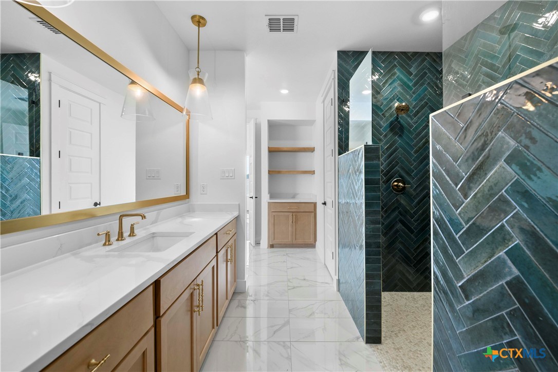 6807 Lacey Oak Road Salado, TX 76571 - Photo 29 of 41 a bathroom with a double vanity sink and a mirror