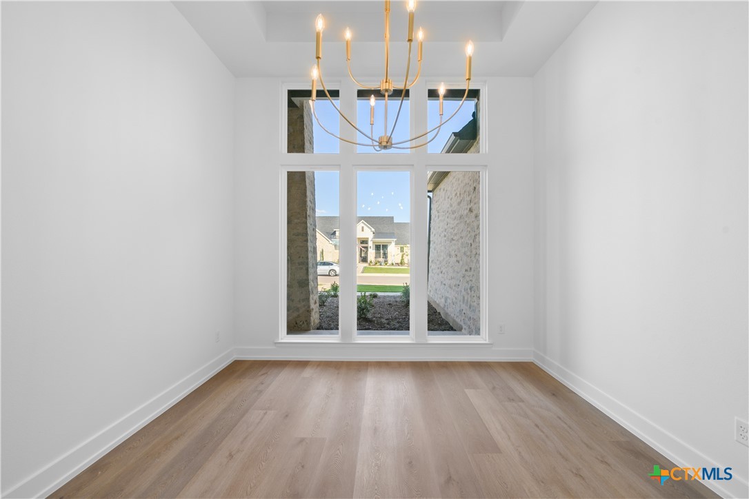 6807 Lacey Oak Road Salado, TX 76571 - Photo 6 of 41 an empty room with a windows and chandelier
