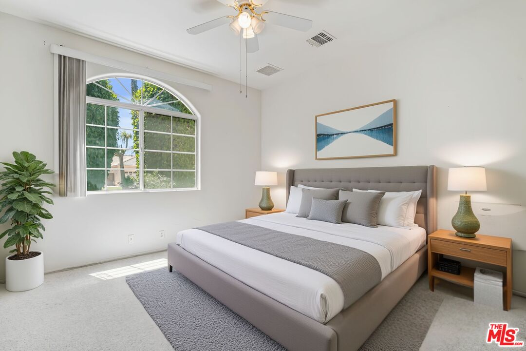 68420 Riviera Road Cathedral City, CA 92234 - Photo 19 of 42 a bedroom with a bed and a potted plant