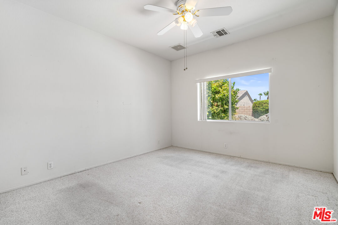 68420 Riviera Road Cathedral City, CA 92234 - Photo 26 of 42 an empty room with windows and chandelier fan
