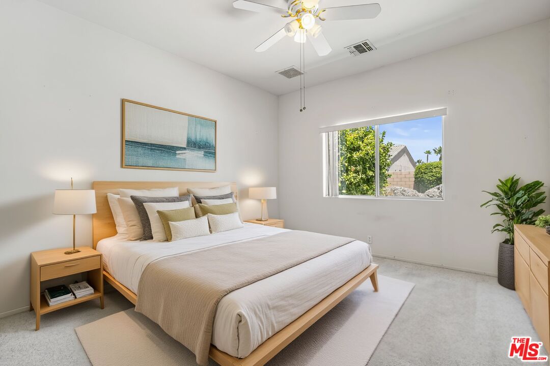 68420 Riviera Road Cathedral City, CA 92234 - Photo 27 of 42 a bedroom with a bed and a painting on the wall