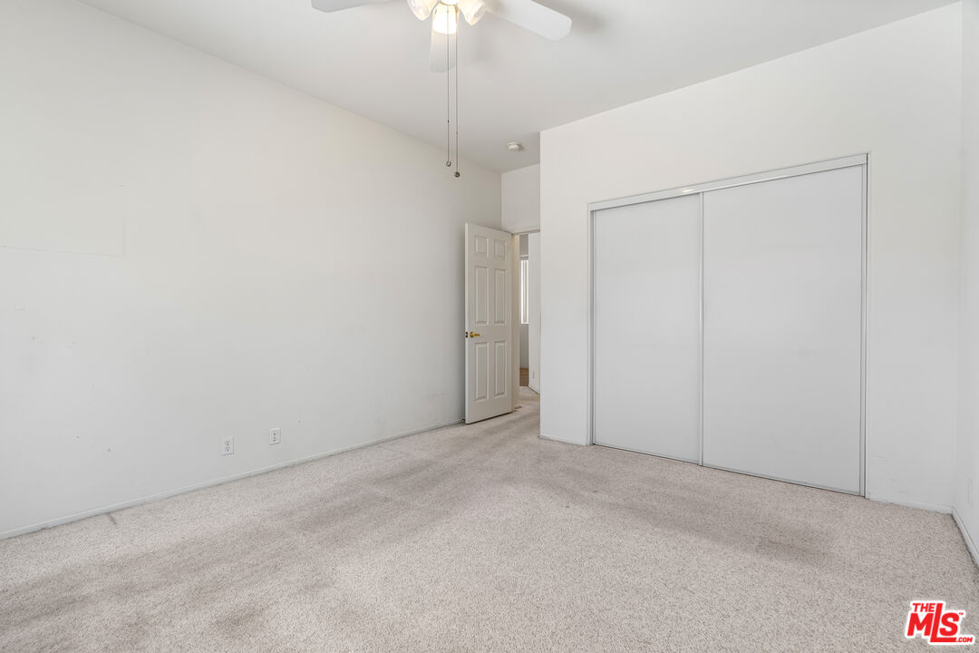 68420 Riviera Road Cathedral City, CA 92234 - Photo 28 of 42 an empty room with a ceiling fan and a window