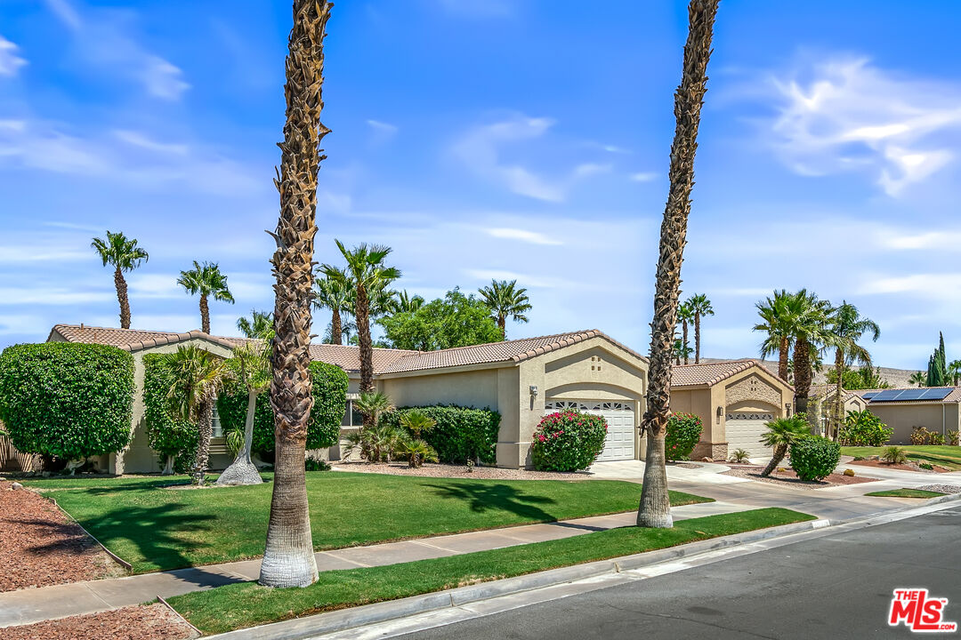 68420 Riviera Road Cathedral City, CA 92234 - Photo 3 of 42 a front view of a house with a yard and palm trees