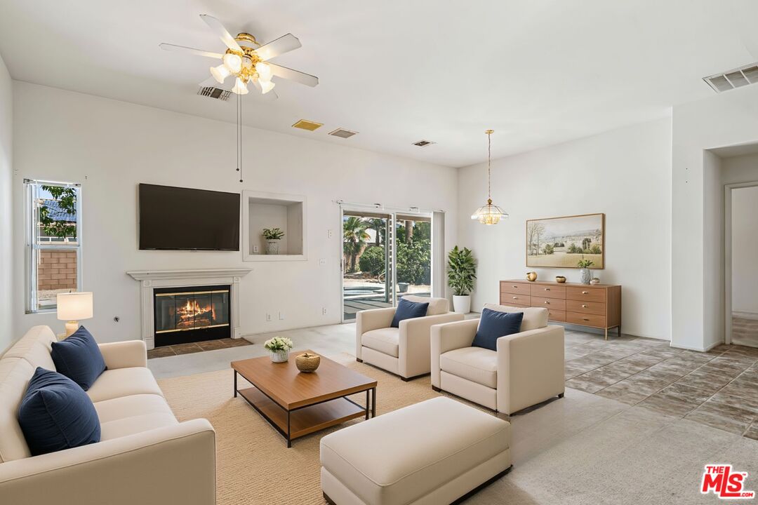 68420 Riviera Road Cathedral City, CA 92234 - Photo 6 of 42 a living room with furniture a fireplace and a flat screen tv