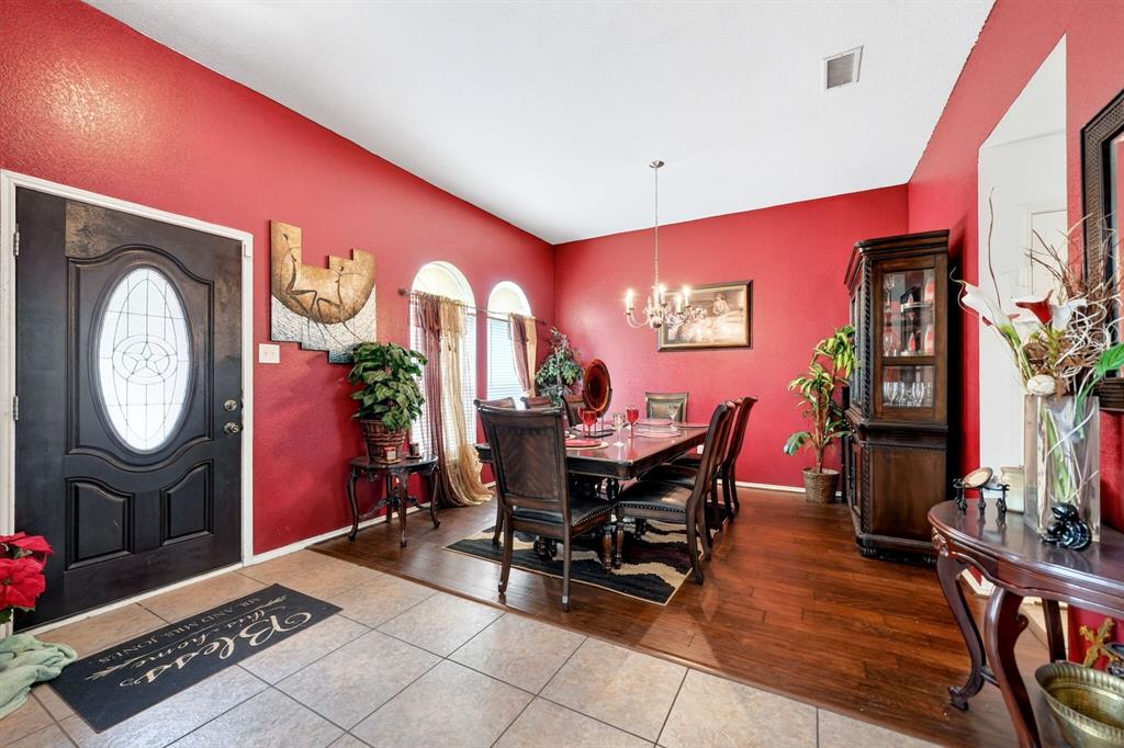 511 Chestnut Trail Forney, TX 75126 - Photo 6 of 32 Formal dining area featuring rich wood-finish flooring, a traditional chandelier, and multiple arched windows