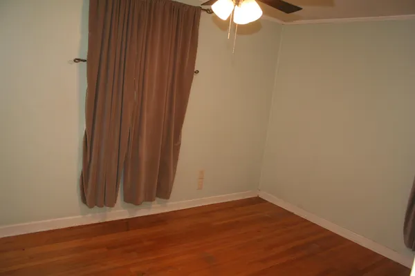 a view of a small space with wooden floor and a window