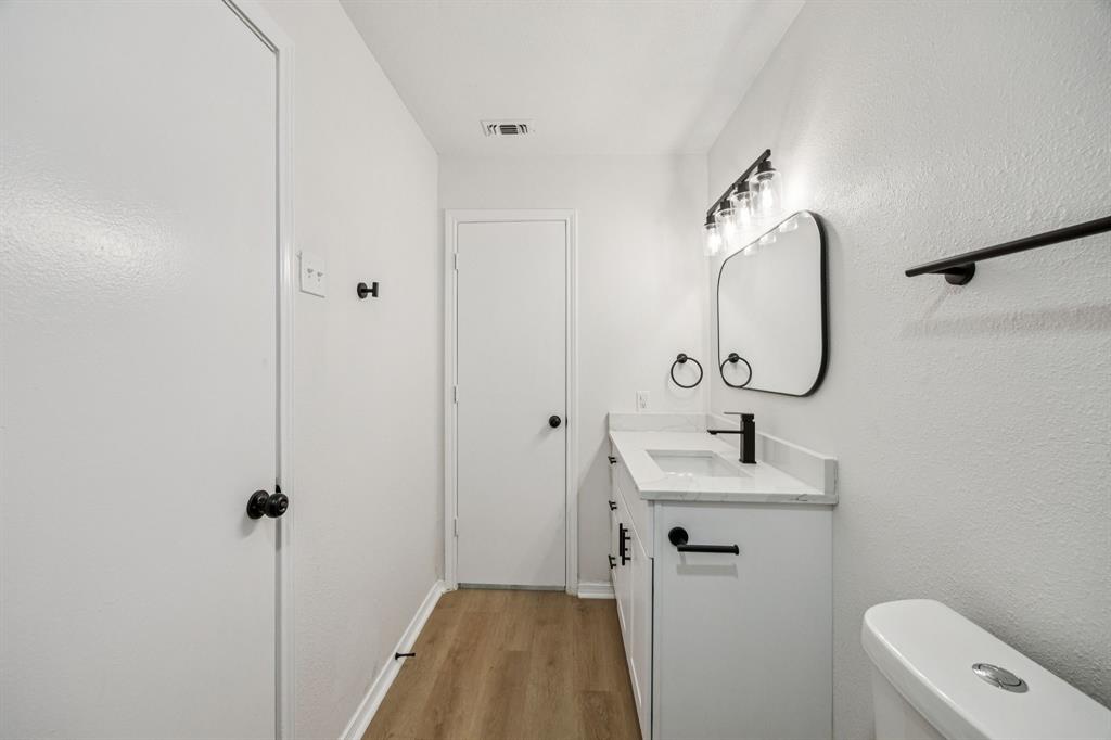 5909 Mark Lane Rowlett, TX 75089 - Photo 16 of 28 a bathroom with a sink and mirror with toilet