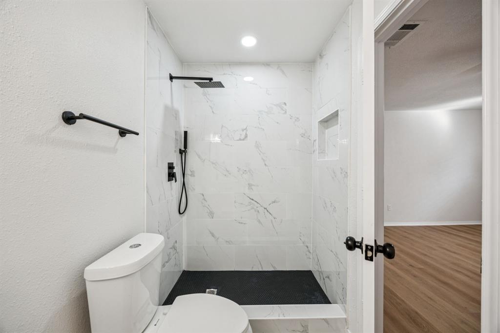 5909 Mark Lane Rowlett, TX 75089 - Photo 17 of 28 a bathroom with a toilet and shower