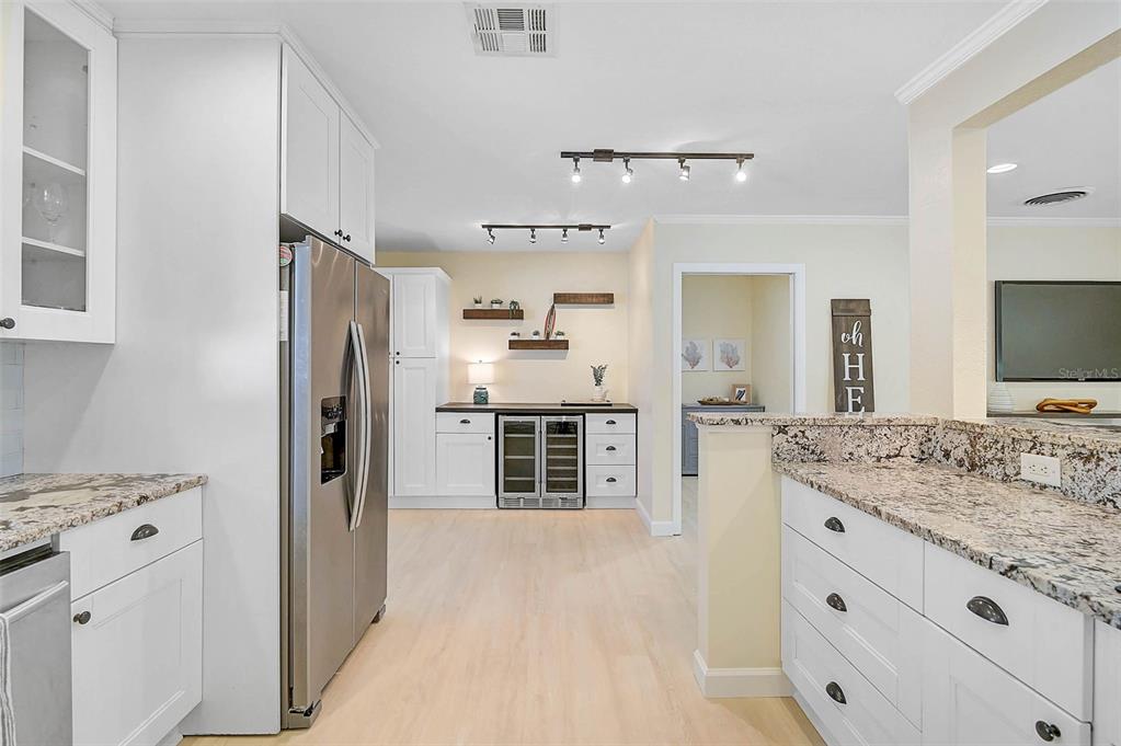 1099 Nokomis Avenue South Venice, FL 34285 - Photo 15 of 68 a kitchen with stainless steel appliances kitchen island granite countertop a refrigerator and a sink