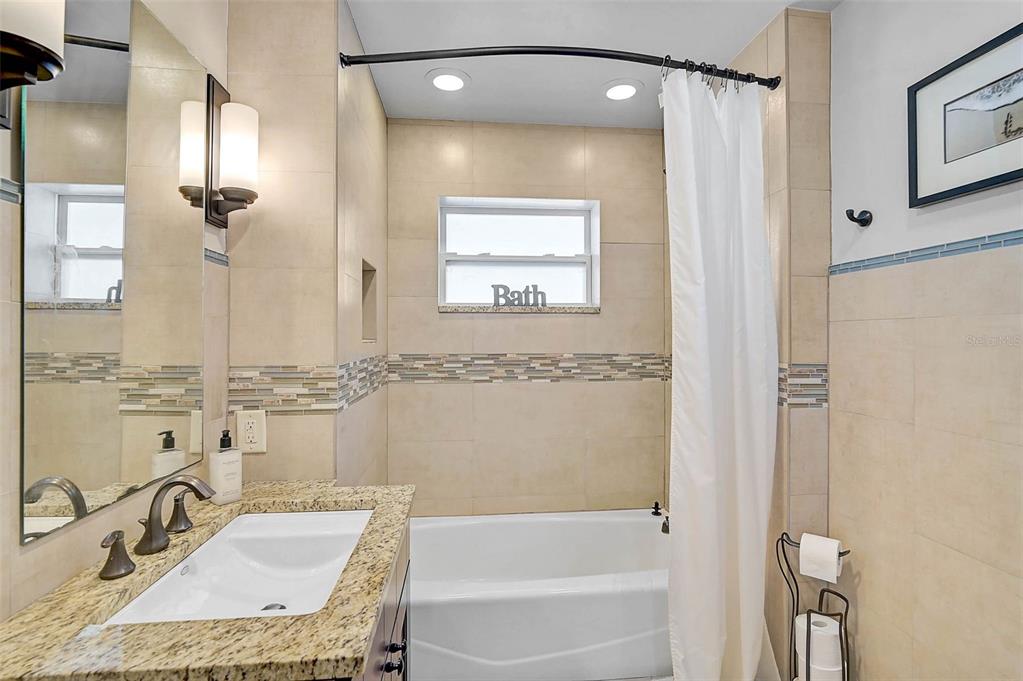 1099 Nokomis Avenue South Venice, FL 34285 - Photo 23 of 68 a bathroom with a granite countertop sink mirror and a bathtub