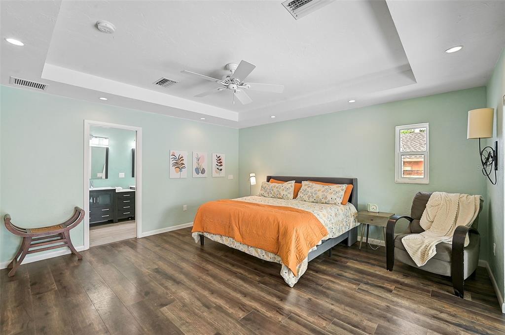 1099 Nokomis Avenue South Venice, FL 34285 - Photo 29 of 68 a spacious bedroom with a bed and a chair