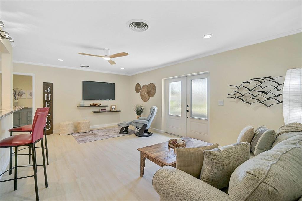 1099 Nokomis Avenue South Venice, FL 34285 - Photo 6 of 68 a living room with furniture a flat screen tv and kitchen view