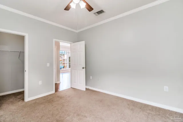 an empty room with chandelier fan