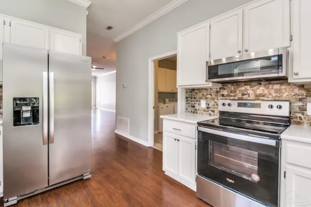 a kitchen with stainless steel appliances a stove a microwave and a refrigerator