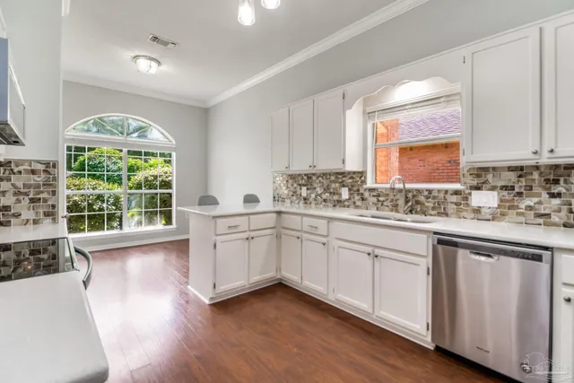 a kitchen with a sink wooden floor and window