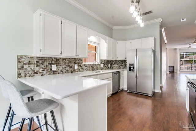 a kitchen with stainless steel appliances a refrigerator sink and wooden floor