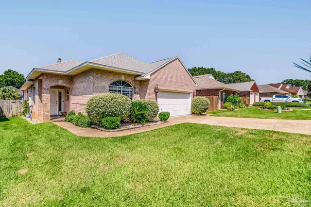 a view of a house with a small yard and a garden
