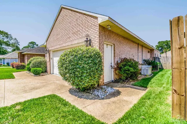 a front view of a house with a yard and potted plants