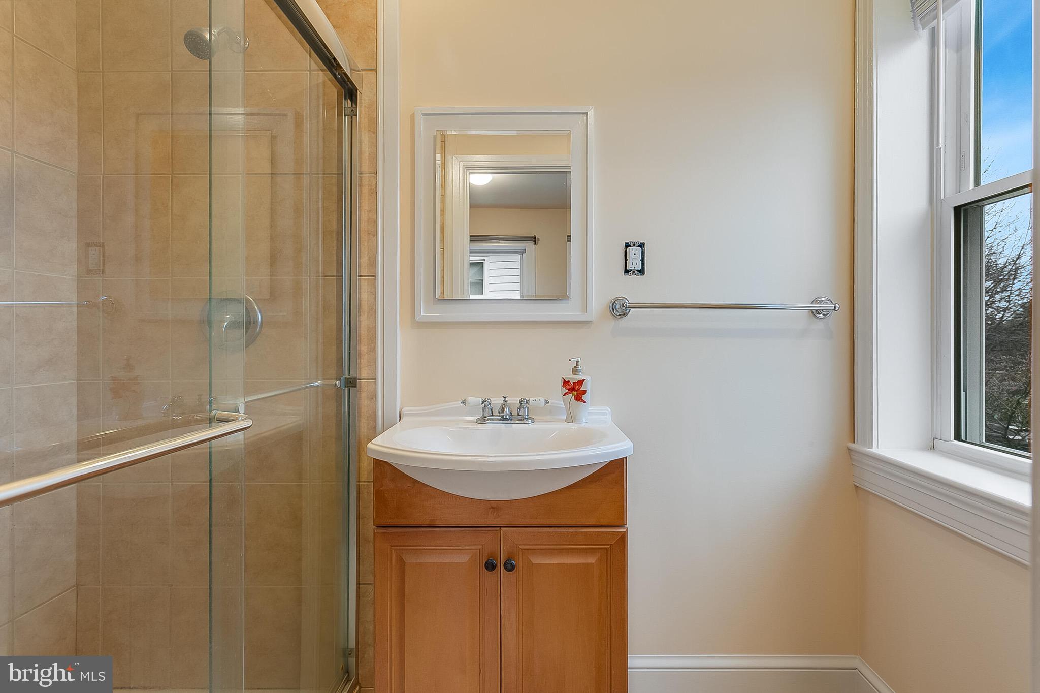 4604 Nottingham Drive Chevy Chase, MD 20815 - Photo 13 of 35 a bathroom with a sink a mirror and a shower