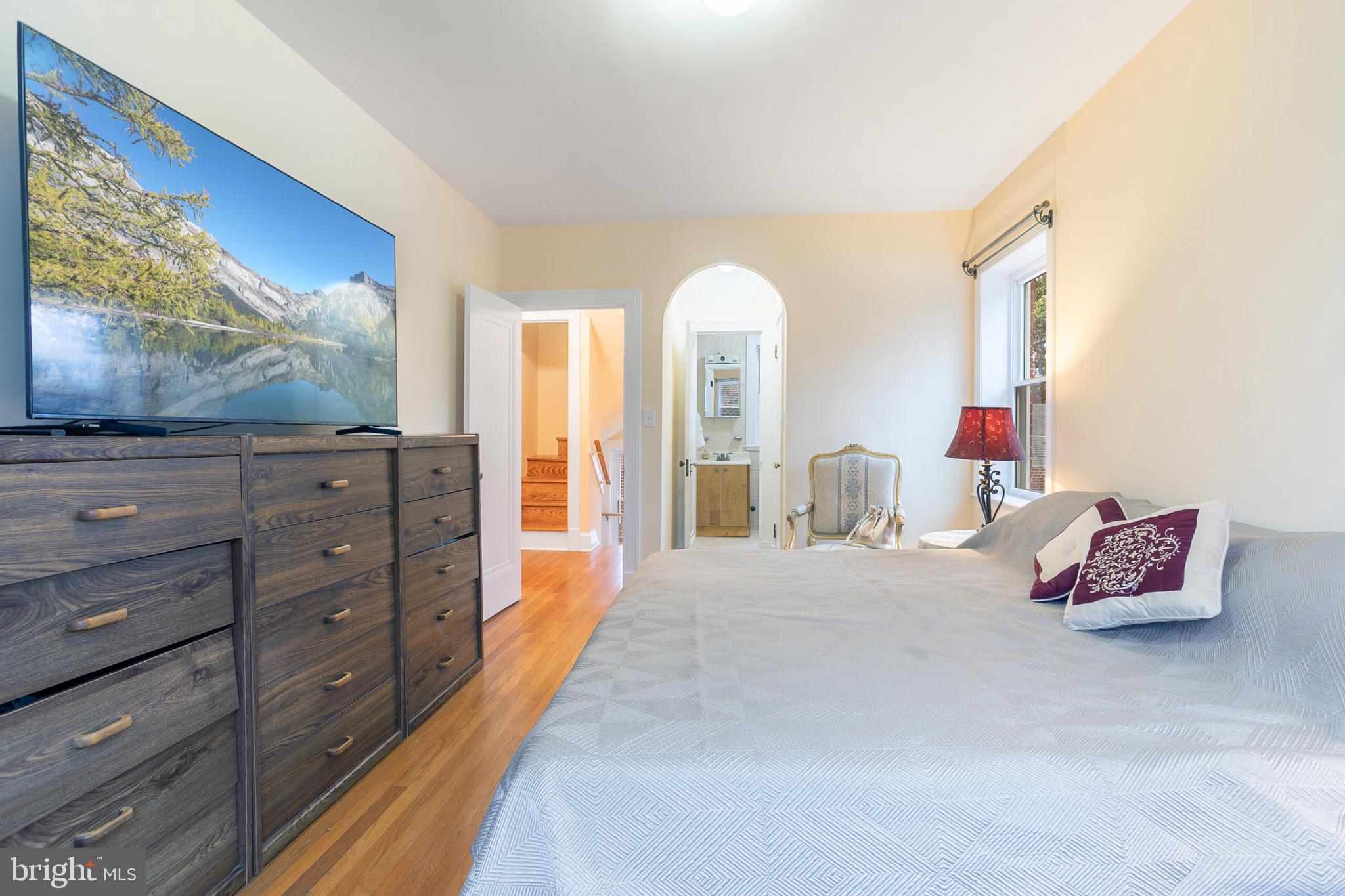 4604 Nottingham Drive Chevy Chase, MD 20815 - Photo 16 of 35 a spacious bedroom with a bed and a flat screen tv