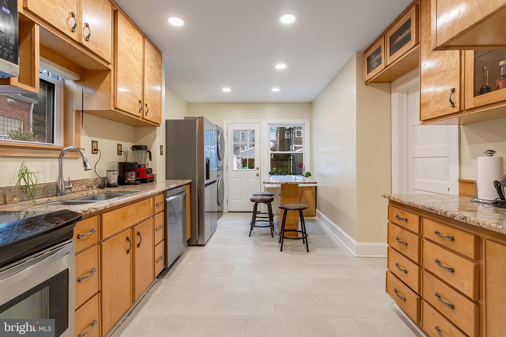 4604 Nottingham Drive Chevy Chase, MD 20815 - Photo 8 of 35 a kitchen with stainless steel appliances kitchen island granite countertop a refrigerator and a sink