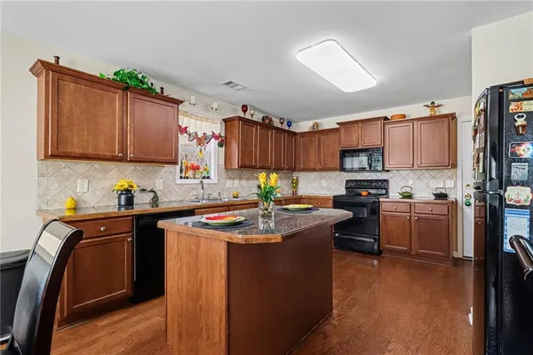 a kitchen with kitchen island granite countertop a sink stove and wooden cabinets