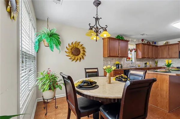 a view of a dining room with furniture a chandelier and wooden floor