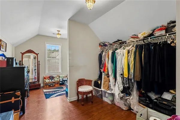 a view of walk in closet with clothes and shoes