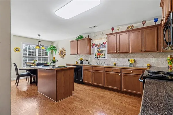 a kitchen with granite countertop a sink stove and cabinets