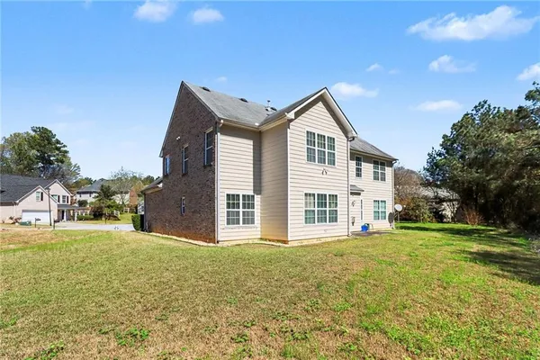a front view of a house with a garden and trees