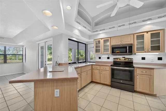 a kitchen with stainless steel appliances granite countertop a stove top oven a sink dishwasher a dining table and chairs with wooden floor