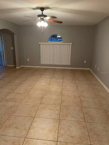 a view of a livingroom with a ceiling fan & rug floor
