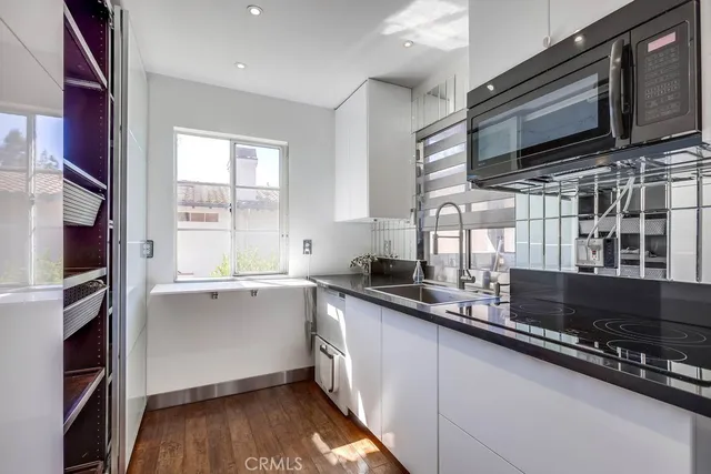 a kitchen with stainless steel appliances a sink dishwasher a microwave oven and a refrigerator