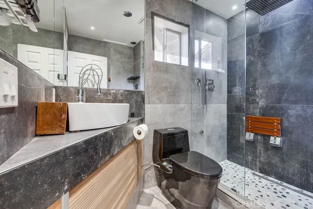a bathroom with a sink a toilet and shower