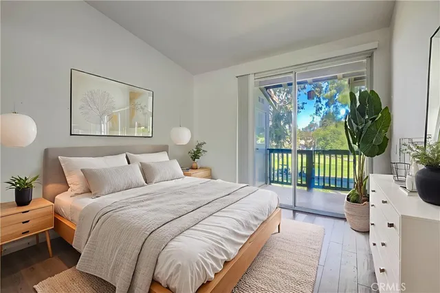 a bedroom with a balcony a bed and a large window