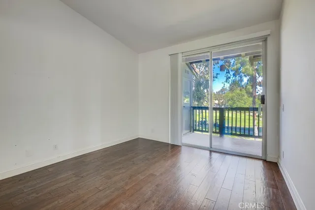 a view of a room with wooden floor and a window