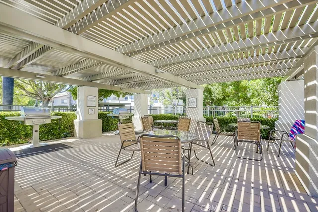 a view of a patio with table and chairs potted plants with wooden floor and fence