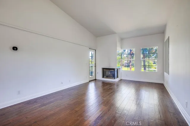 an empty room with wooden floor and fireplace